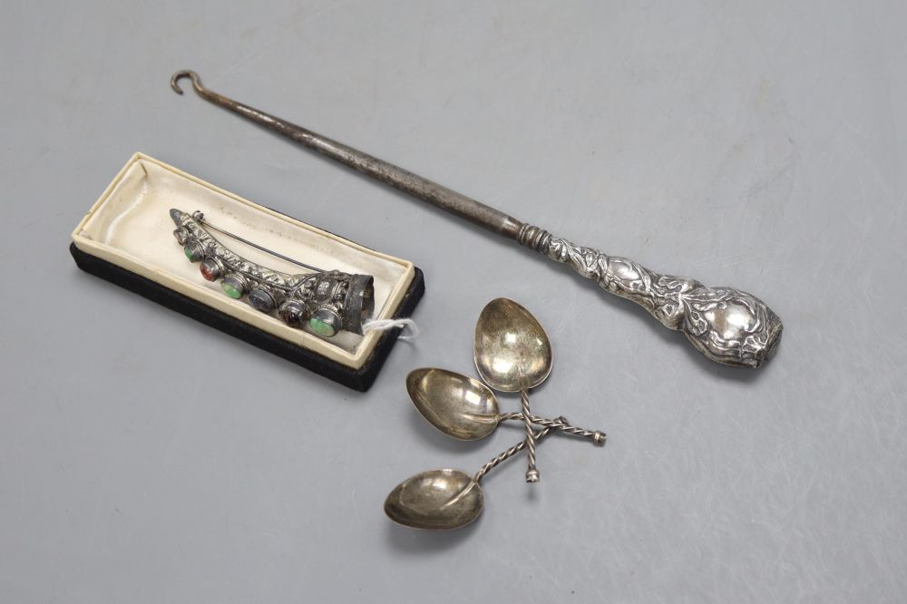 A Chinese silver and hardstone finger ornament with brooch pin, a buttonhook and a set of three small Arts & Crafts silver spoons
